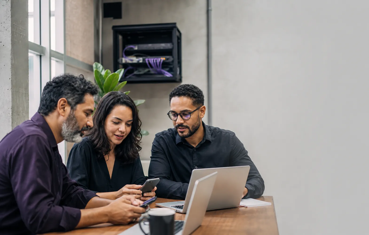Equipe de uma empresa brasileira trabalhando com notebooks e smartphones